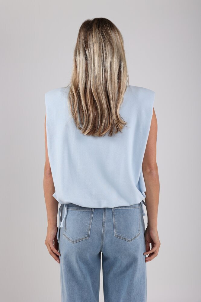 Pull bleu sans manches avec un lien à nouer en bas, signé Babette Nukus