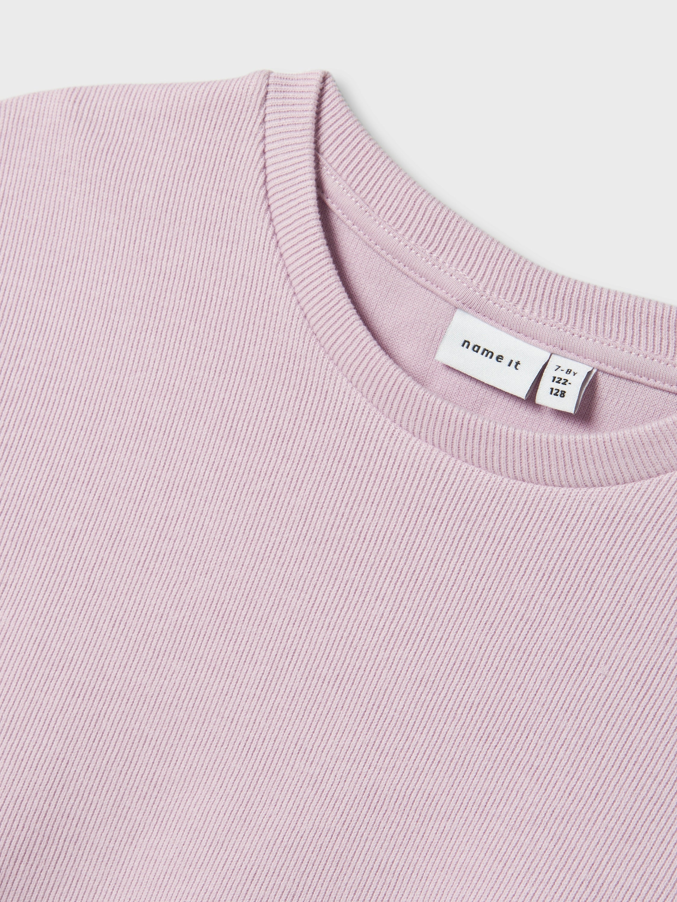 T-shirt rose en tissu côtelé à manches bouffantes. Nomme-le