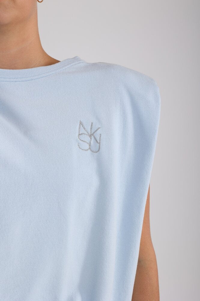 Pull bleu sans manches avec un lien à nouer en bas, signé Babette Nukus